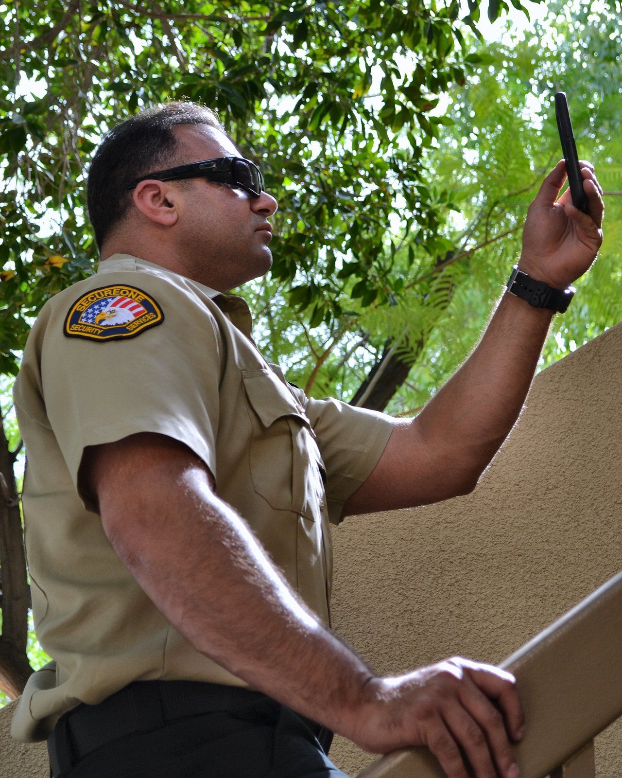 SecureOne security officer filing a patrol check on a phone